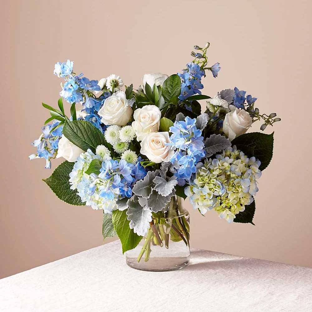 Cielos Abiertos, Arreglo de flores de condolencias para el hogar, elaborado con flores de hortensias y belladona delfinio que captura la sensación de un nuevo dÃa, Fresh Flowers Orlando.