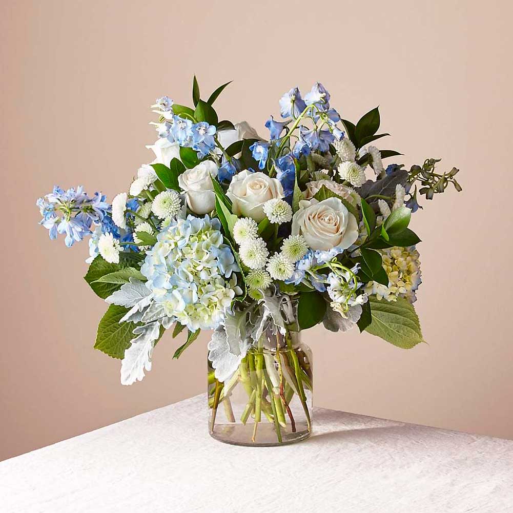 Cielos Abiertos (Symphaty Funeral Flowers), Arreglo de flores de condolencias para el hogar, elaborado con flores de hortensias y belladona delfinio que captura la sensación de un nuevo dÃa, Fresh Flowers Orlando.