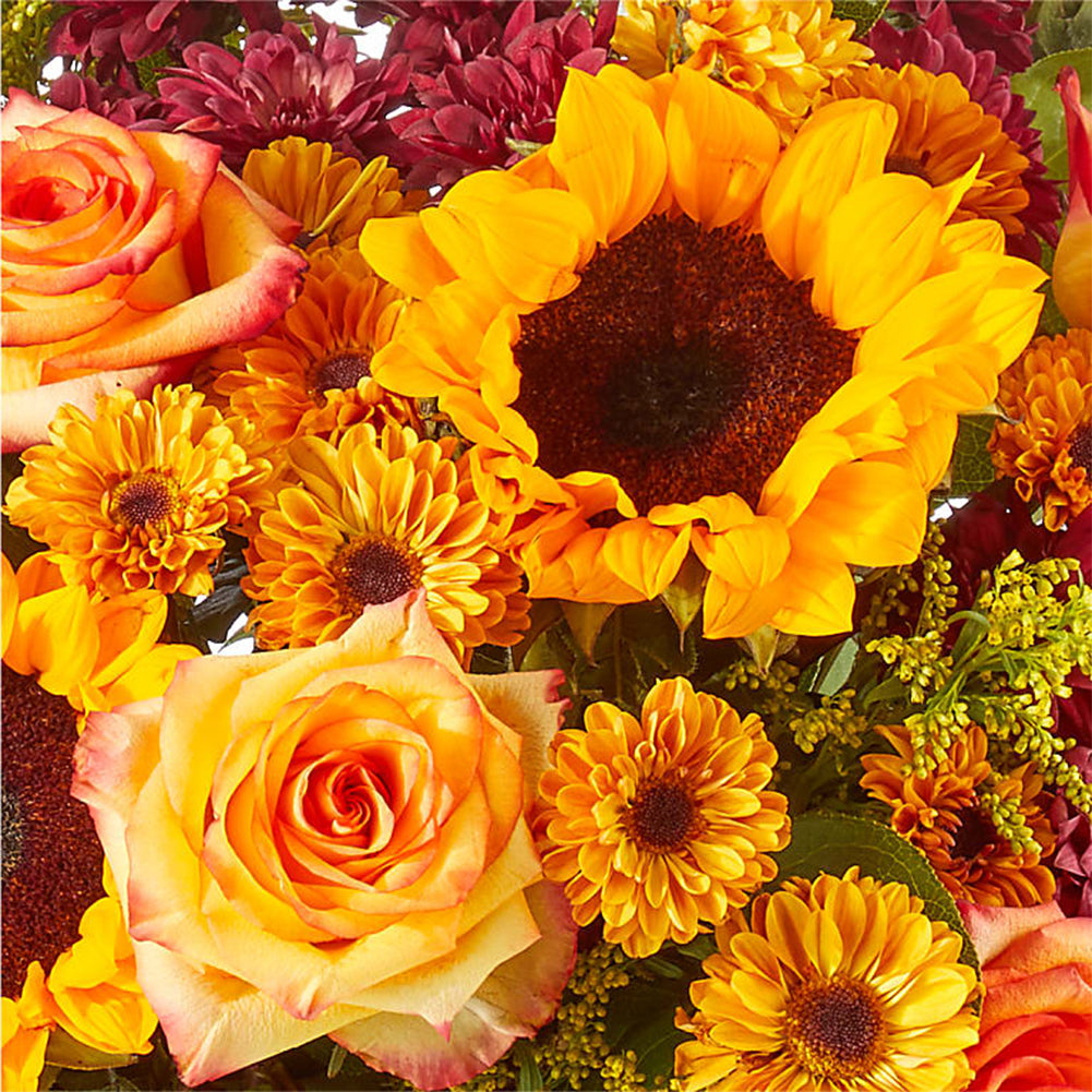 Girasoles y rosas en jarrón transparente