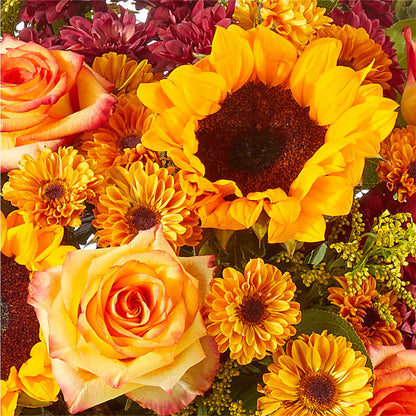 Girasoles y rosas en jarrón transparente