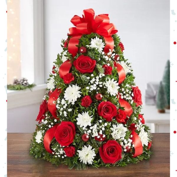 Árbol de Flores Navideñas Large. ¡El tradicional árbol favorito de las fiestas en donde empezó todo! Nuestro arreglo de árbol de flores es popular por su estética festiva y su tamaño compacto, que se adapta a cualquier entorno. Detalles del arreglo: Rosas Rojas y mini Claveles; Cojines blancos; Acentuado con baby’s breath, vegetación navideña variada, adornos y un lazo rojo en la parte superior. Domicilio Gratis Orlando FL, Fresh Flowers Orlando.