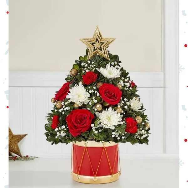 Árbol Musical de Flores Navideñas Medium. En la última edición de nuestro clásico árbol de flores navideño, la alegría de hacer regalos cobra vida. Hemos añadido flores festivas, adornos dorados brillantes y una estrella en la parte superior. Detalles del arreglo: Rosas Rojas, Mini Claveles, Colores verdes navideños, Domicilio Gratis Orlando FL, Fresh Flowers Orlando.