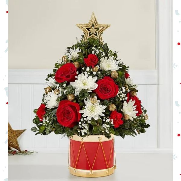 Árbol Musical de Flores Navideñas Large. En la última edición de nuestro clásico árbol de flores navideño, la alegría de hacer regalos cobra vida. Hemos añadido flores festivas, adornos dorados brillantes y una estrella en la parte superior. Detalles del arreglo: Rosas Rojas, Mini Claveles, Colores verdes navideños, Domicilio Gratis Orlando FL, Fresh Flowers Orlando.