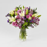 Lavender Fields Mixed Flower, white Asiatic Lilies, Purple Super Select Alstroemeria, Purple Button Pom, Lavender Daisy Pom, Purple Sinuata Statice, and an assortment of lush greens. Fresh Flowers Orlando.