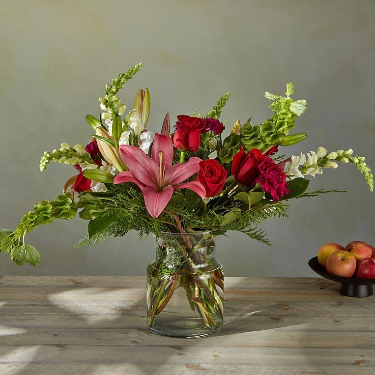 Ramo de Estrellas de Navidad Premium. Las Bocas de Dragón blancas y los Lirios híbridos junto con las Rosas, añaden un sutil cambio a la paleta navideña convencional en este ramo. Detalles del arreglo: Claveles, rosas, lirios, Campanas de Irlanda y Boca de Dragón, colores verdes navideños. Domicilio Gratis Orlando FL, Fresh Flowers Orlando.